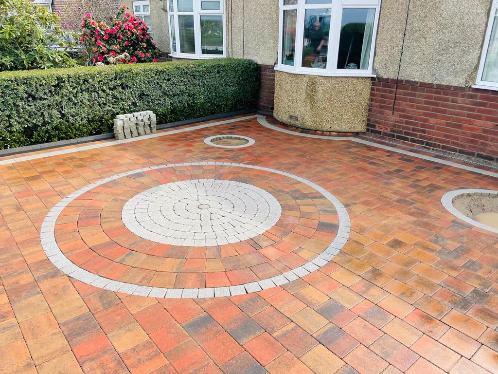 Red and autumn block paved driveway with a circular feature ringed in silver granite setts — The Vale Company