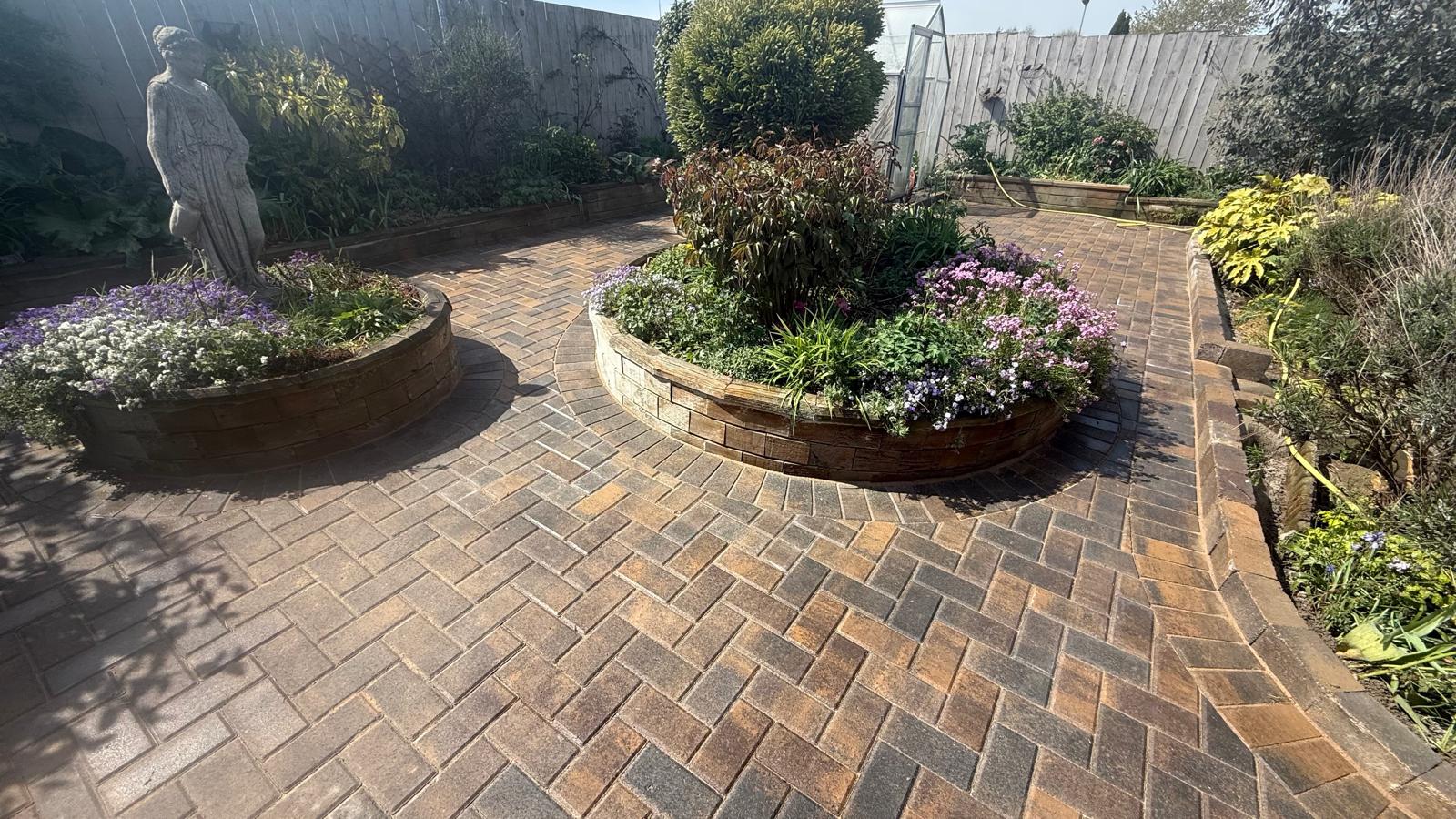 Brindle block paved courtyard with circular raised beds — The Vale Company