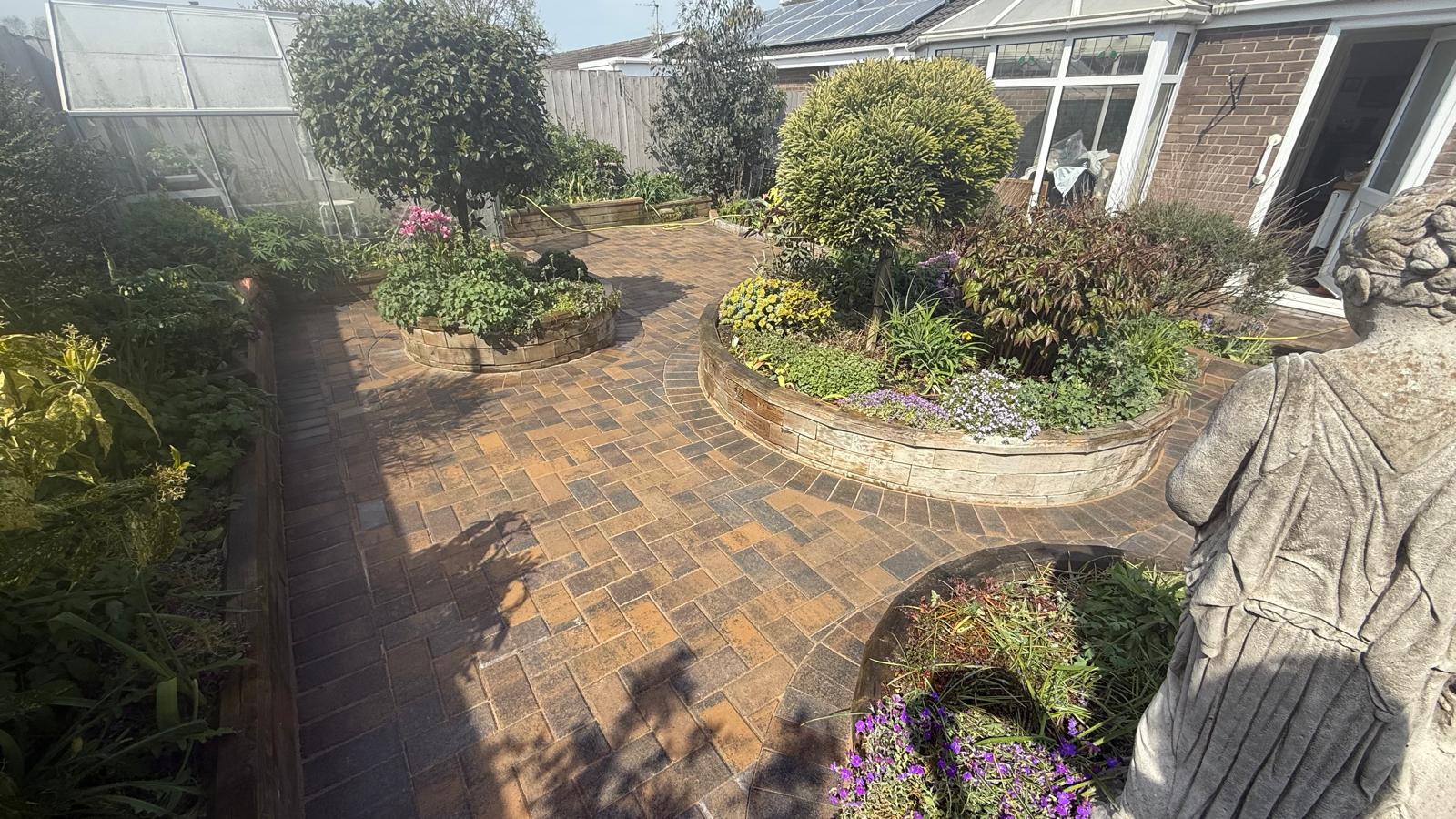 Brindle block paving cut around a circular raised bed — The Vale Company