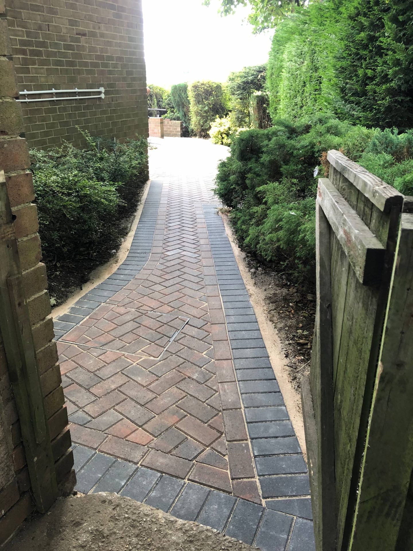 Brindle block herringbone side path with a charcoal double border and a recessed cover set into the coursing — The Vale Company