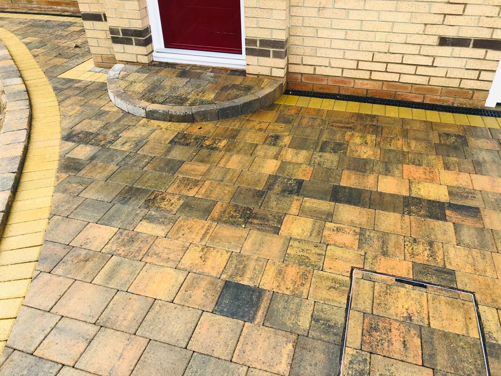 Buff block paved driveway with a radius entrance step and a recessed inspection cover infilled to match — The Vale Company