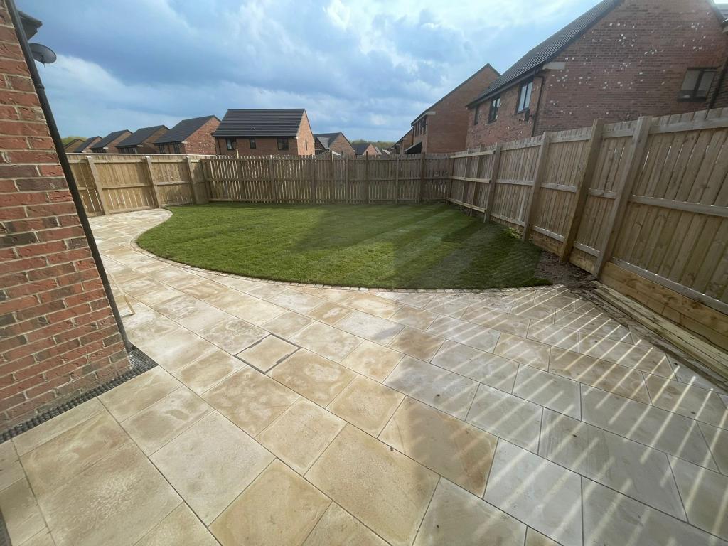 Buff riven slab patio with a curved edge to freshly laid turf — The Vale Company