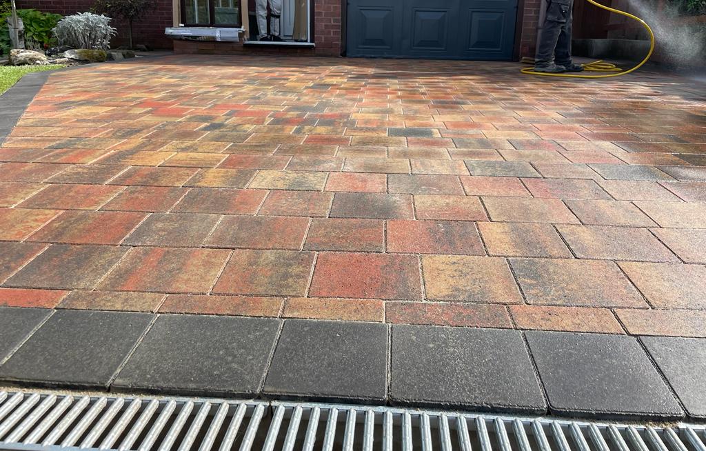 Linear channel drain across a block driveway in front of a garage door — The Vale Company