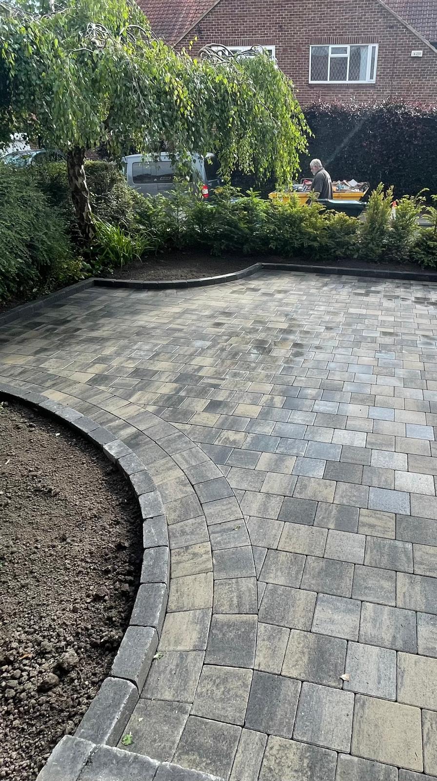 Block paved driveway curving to a house entrance with radius edging — The Vale Company