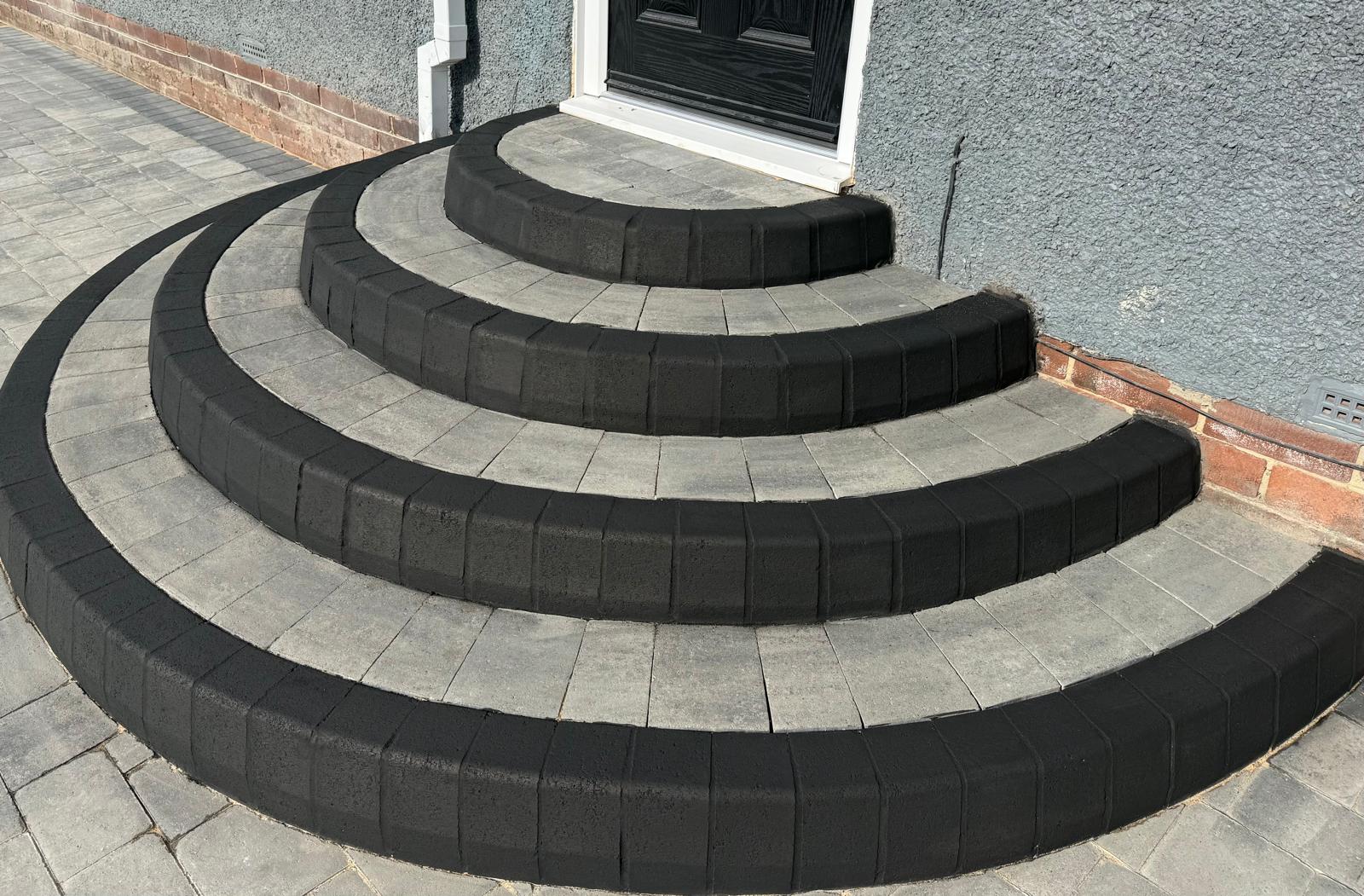 Four-tier curved entrance steps with charcoal bullnose nosings and silver block treads — The Vale Company