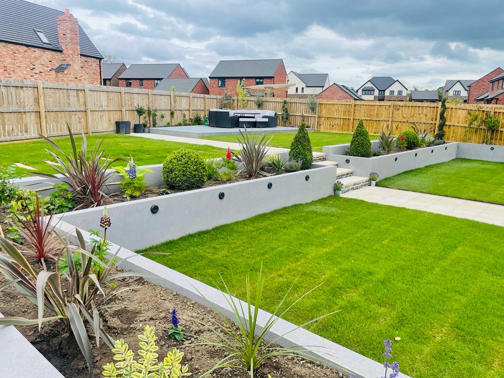 Full garden build with rendered retaining walls, inset lighting, new turf and a porcelain seating terrace — The Vale Company