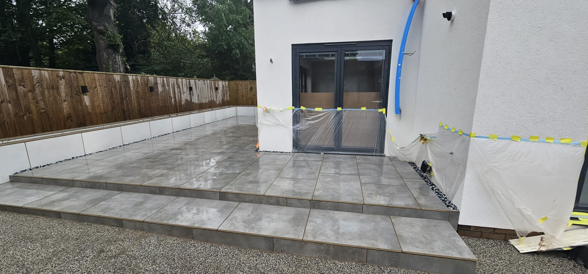 Grey porcelain terrace with two-tier porcelain steps and a gravel drainage margin — The Vale Company