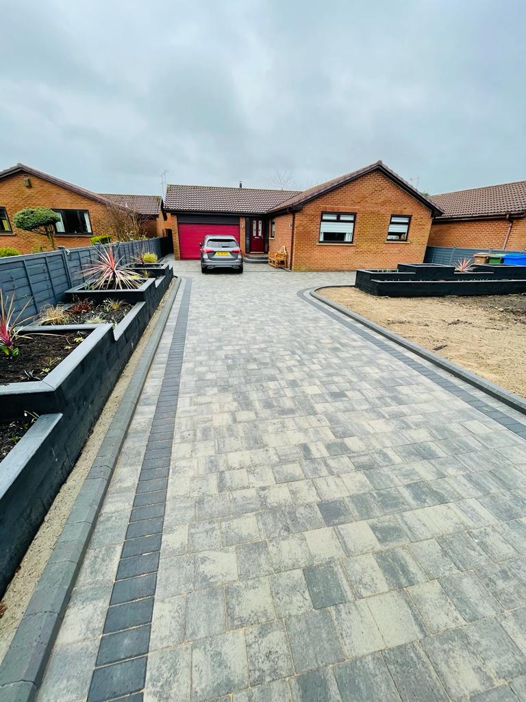Long block paved driveway with charcoal soldier courses running down both sides — The Vale Company