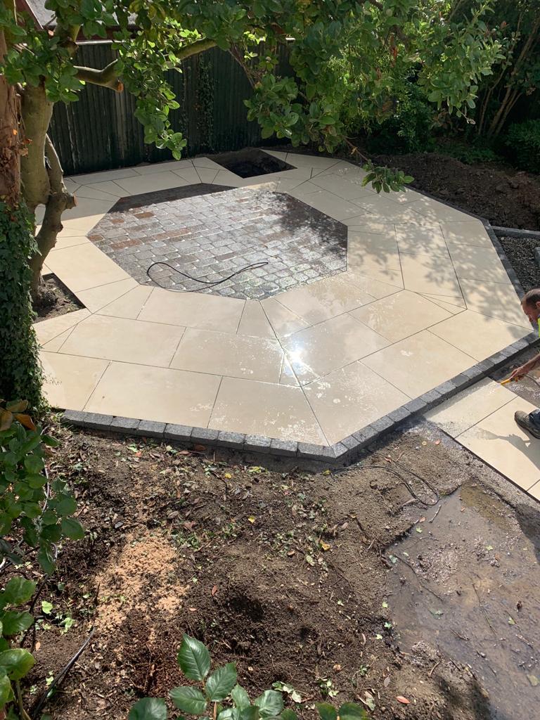Octagonal cream porcelain patio with a granite sett border and a cobble-set centre panel — The Vale Company