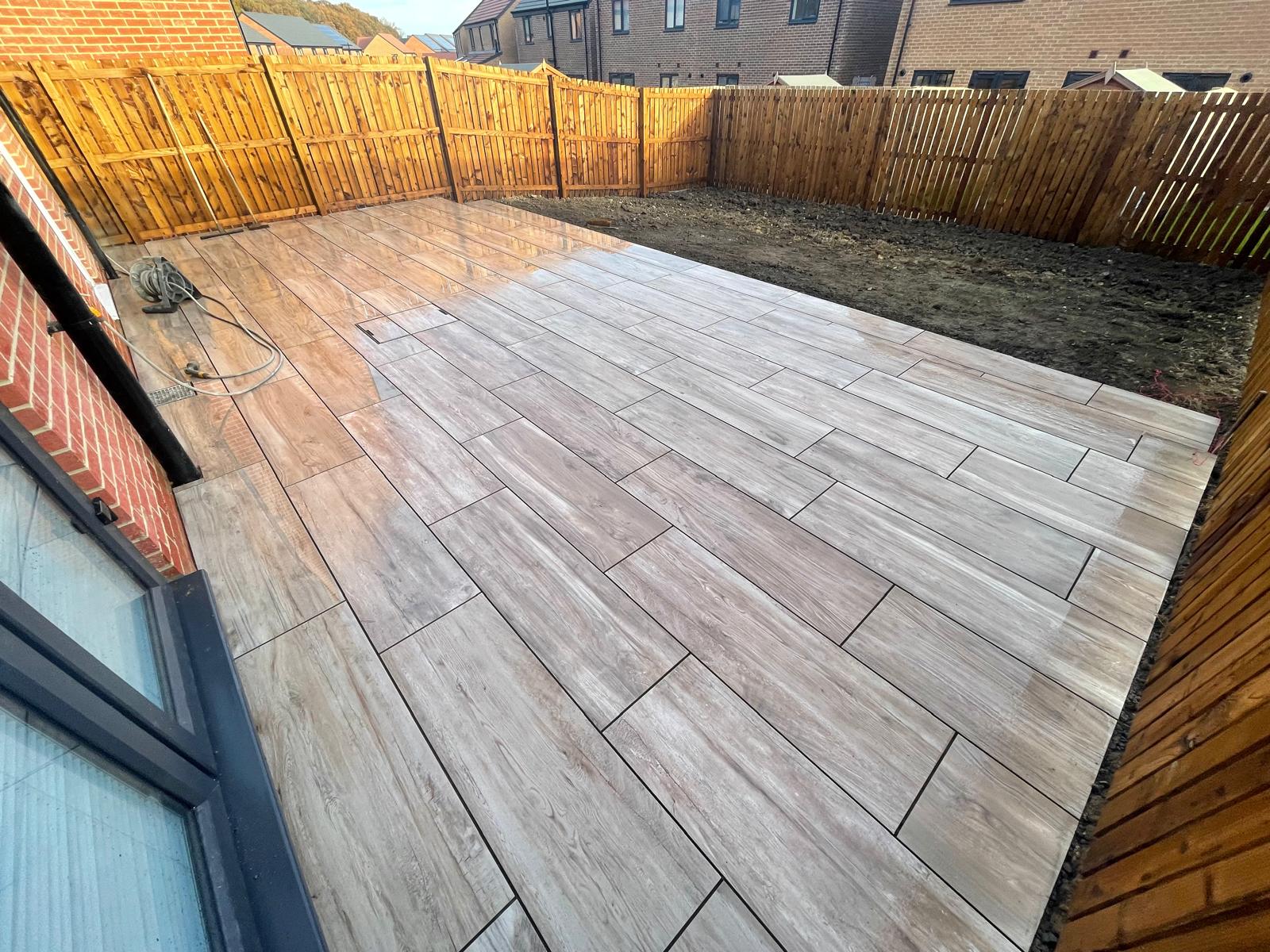 Wide plank wood-effect porcelain terrace across a new-build garden — The Vale Company