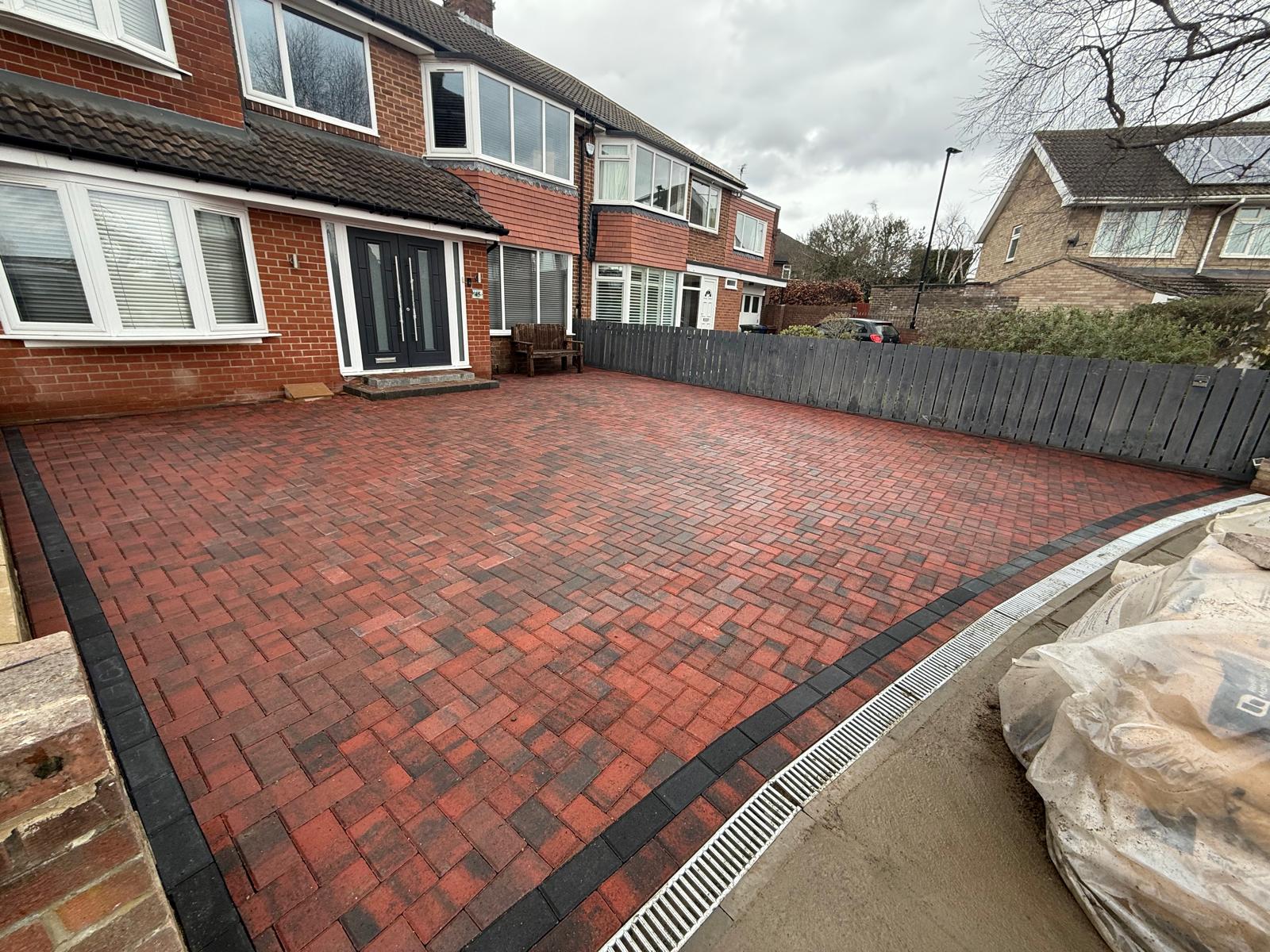 Red block driveway laid in herringbone with a double charcoal border — The Vale Company