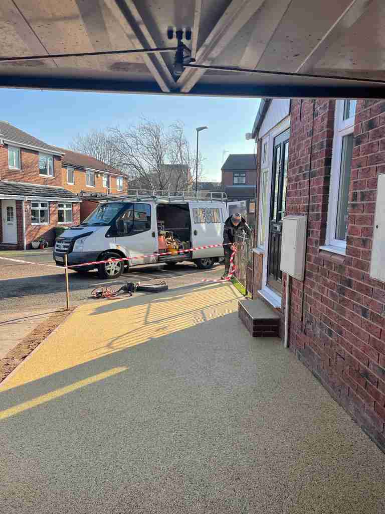 Resin bound surfacing being laid and taped off at a front entrance and side path — The Vale Company