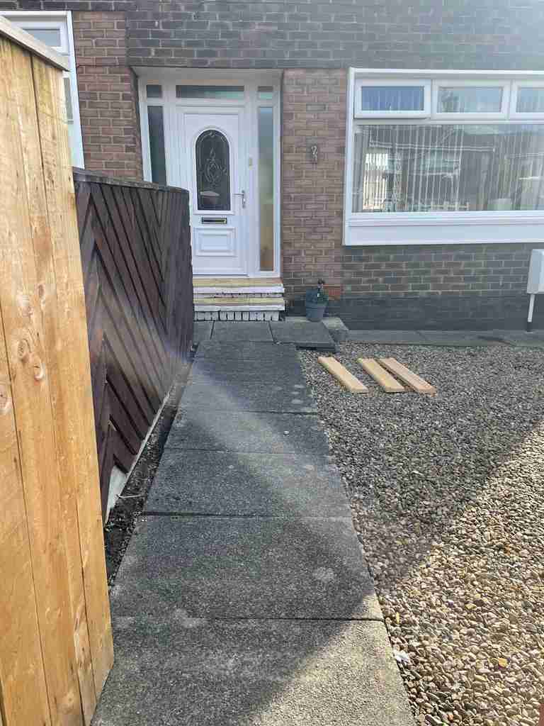 Before: worn concrete slab path and loose gravel at a front entrance — The Vale Company