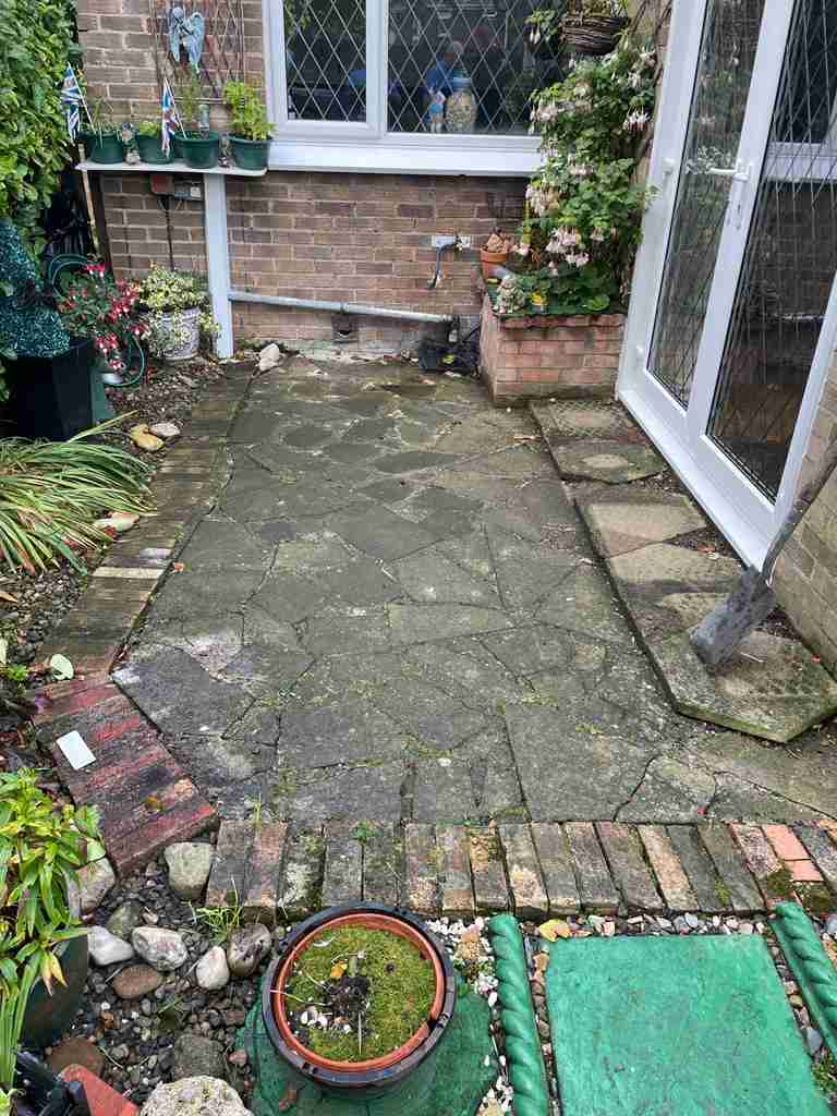 Before: mossy crazy paving at a patio door — The Vale Company