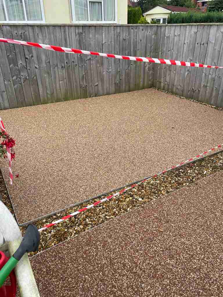 Completed resin bound patio with an aluminium edge rail and a gravel drainage margin — The Vale Company