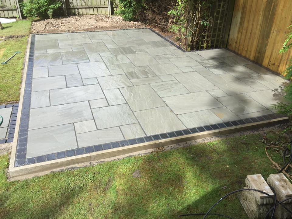 Grey silver Indian sandstone patio with a brick soldier-course border — The Vale Company
